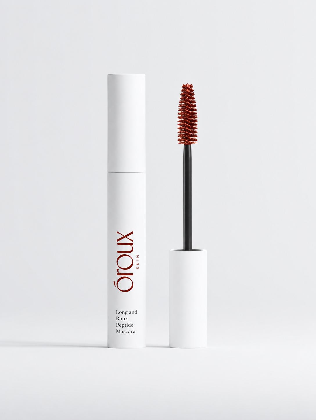 Oroux Long and Roux Peptide Mascara shown with its white cylindrical tube and the applicator wand, featuring a dark auburn mascara formula, on a clean white background.
