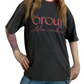 A person wearing a faded black graphic t-shirt with 'órou golden red' printed in red script across the chest, paired with blue jeans.