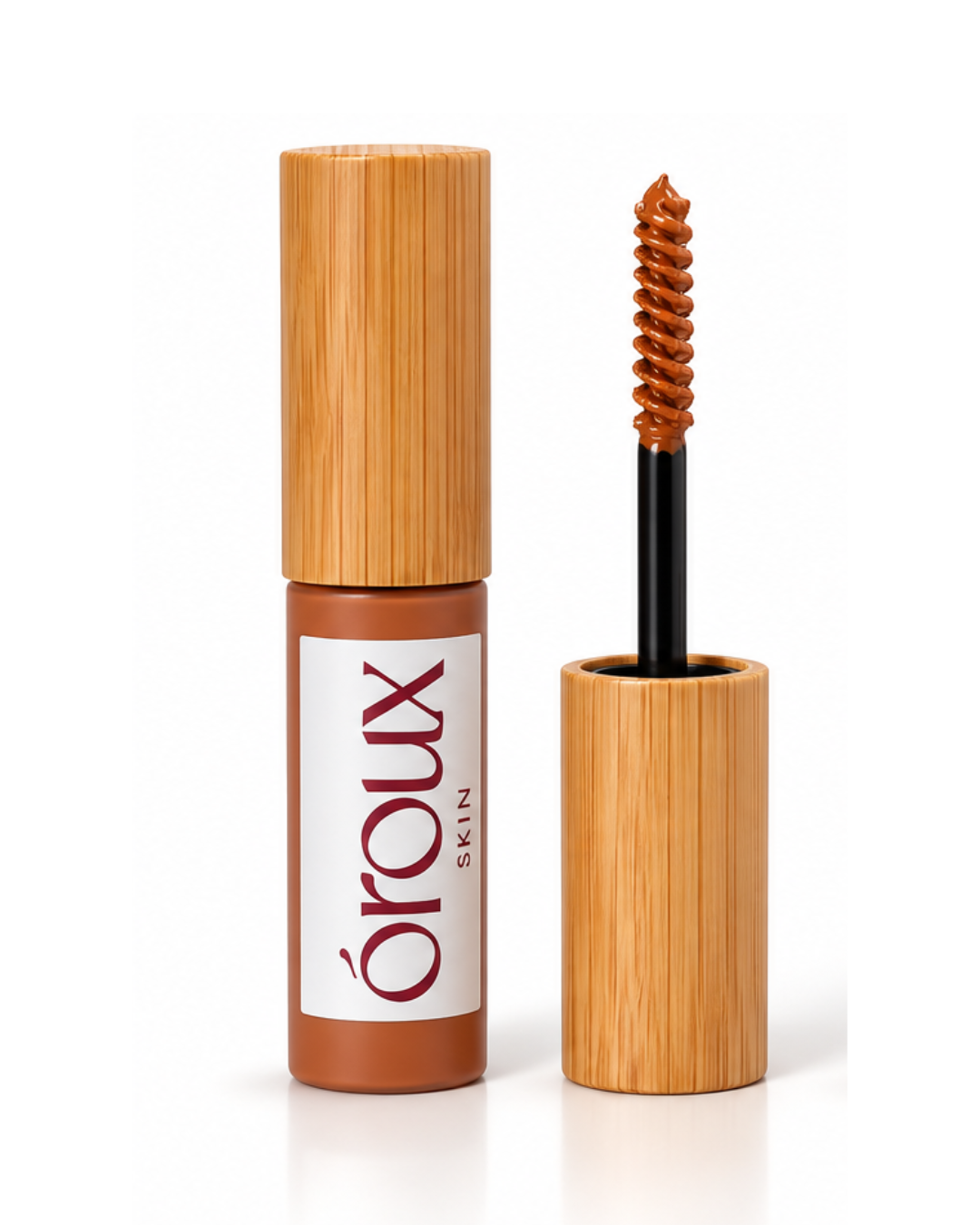 A strawberry blonde brow gel by oroux Skin, shown with its bamboo-textured cap off and the applicator wand standing beside it on a white background.