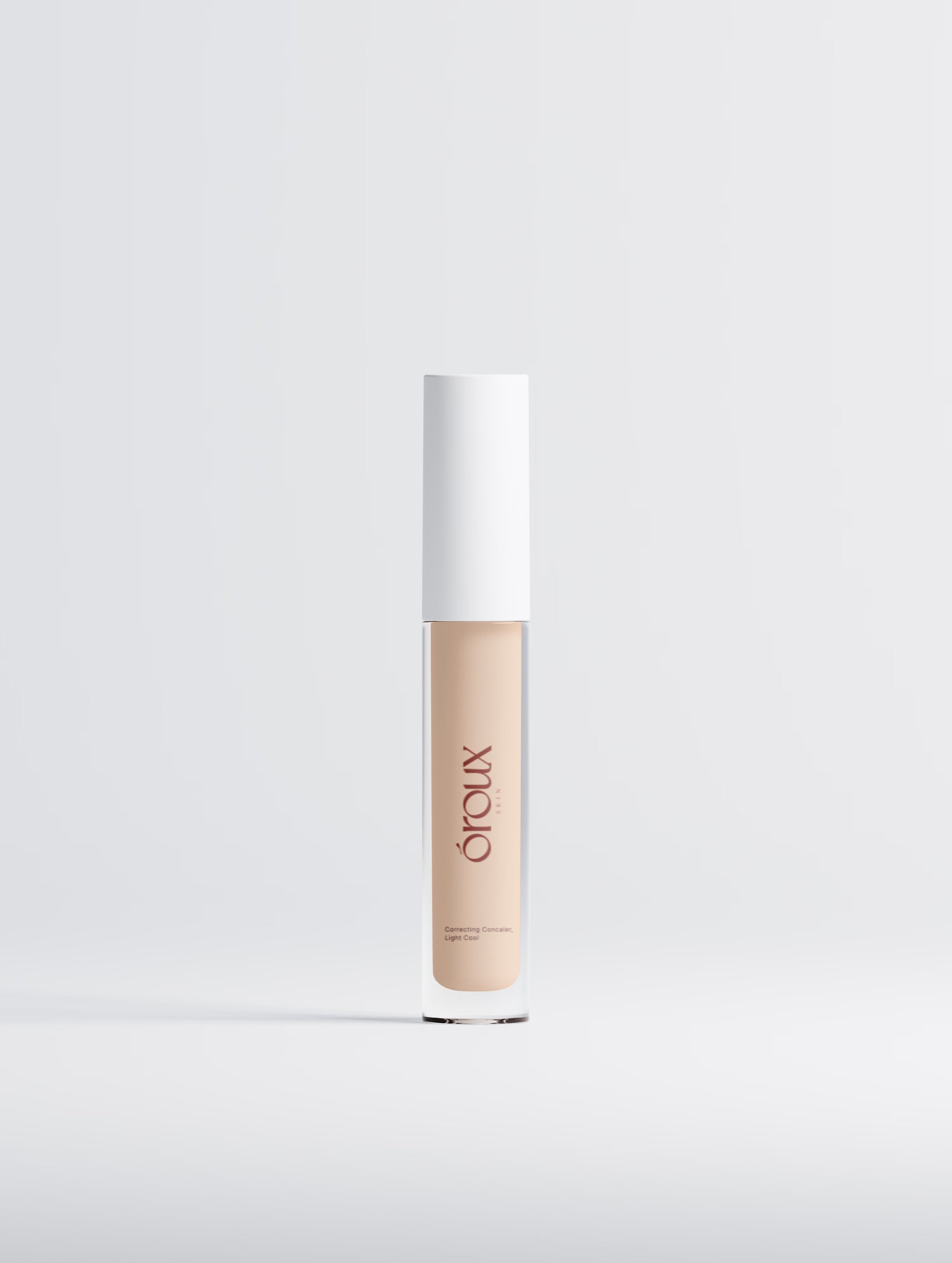 Cosmetic concealer bottle with white cap on a light gray background