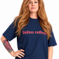 A split-screen lifestyle image of a woman with long red hair modeling a navy blue t-shirt. The left side shows her from the waist up with her hand on her hip, and the right side shows a closer cropped view of her flexing her arm.