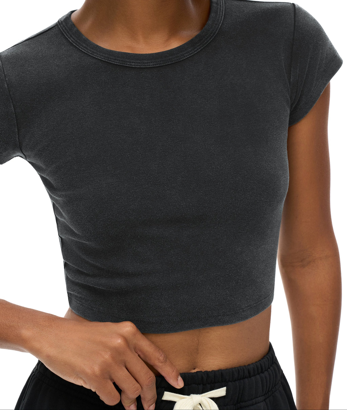 Person wearing a dark gray crop top on a white background