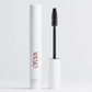 A white cosmetic tube labeled óroux with the wand removed and standing beside it on a clean light gray studio background.