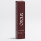 A tall, slim rectangular box of Óroux Skin Lengthening & Volumising Mascara in a deep burgundy color, standing upright on a light gray background.