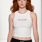 A model walks down a fashion runway wearing a white ribbed crop top with 'michael goldstein' printed in red script across the chest, paired with black sweatpants with a white drawstring.