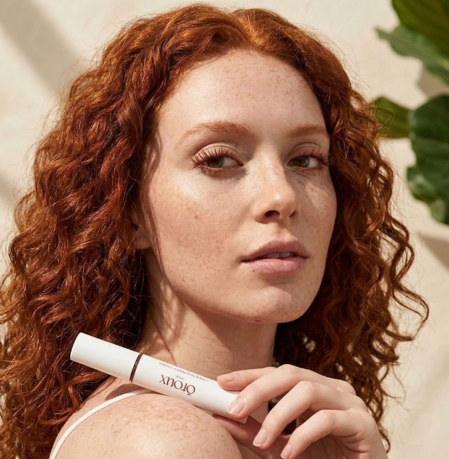 redhead holding oroux skin long and roux mascara for redheads and gingers